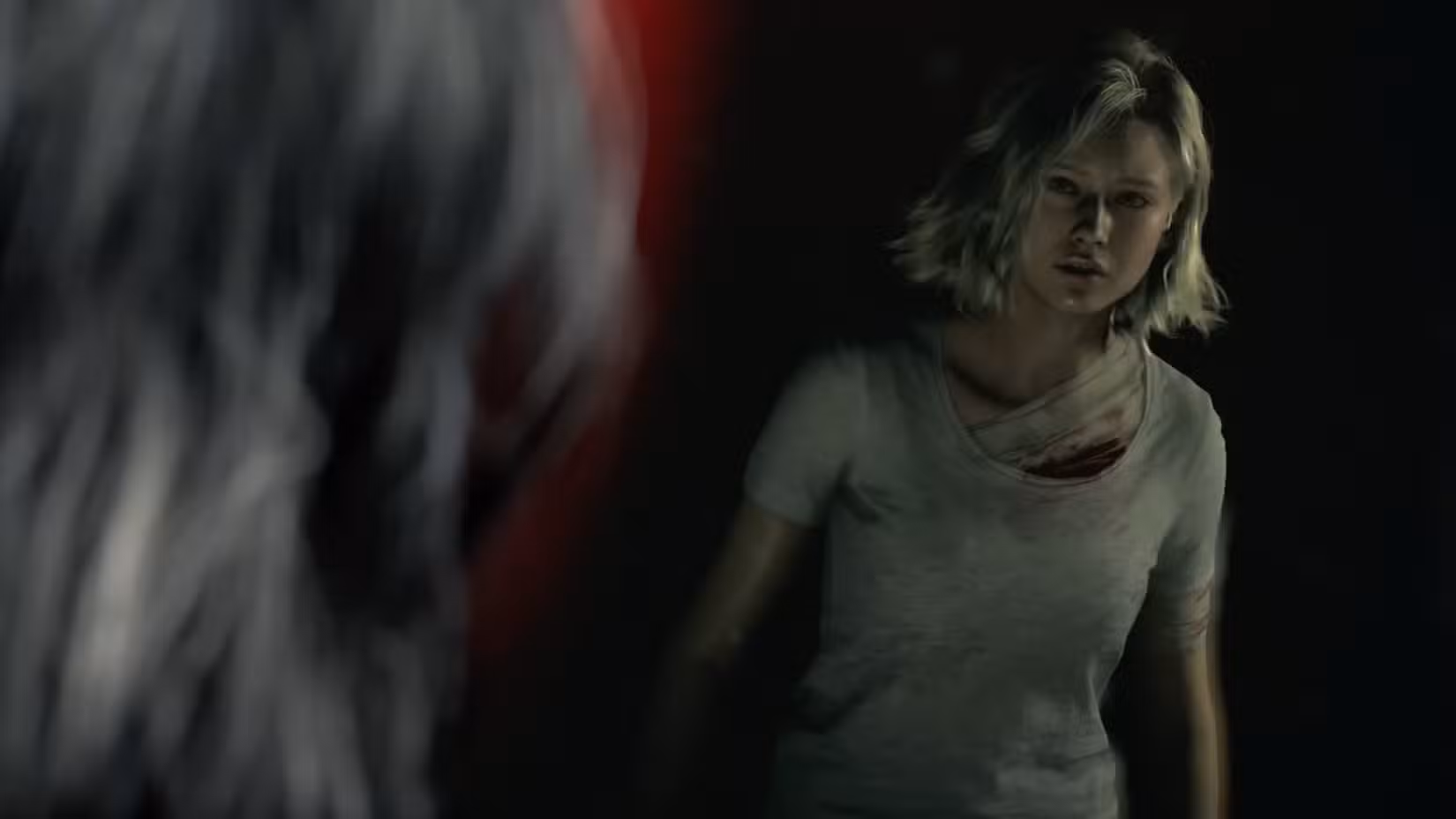 Grace, uma jovem de cabelo loiro curto e branco, olha seu reflexo no espelho.