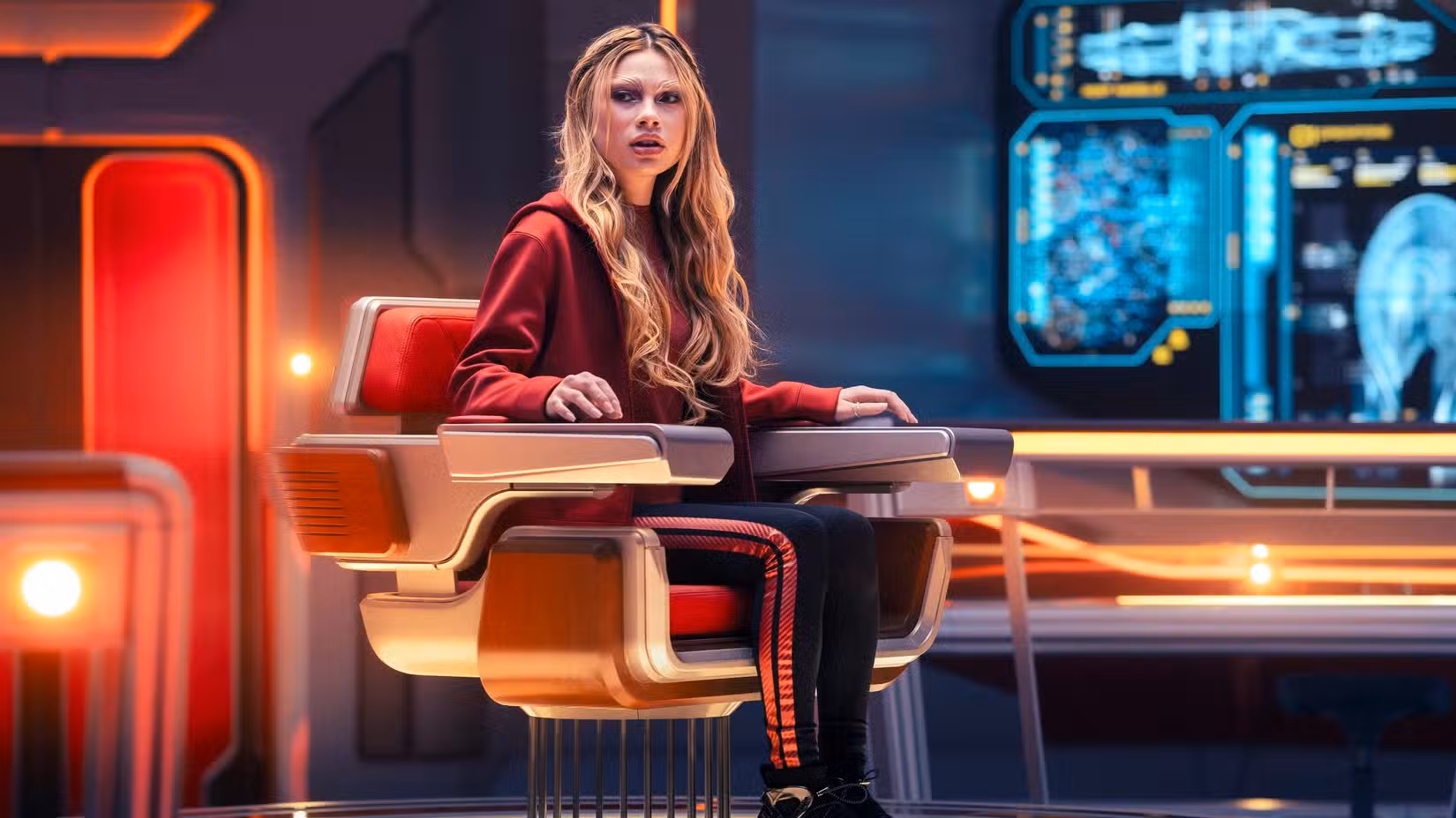 Genesis Lythe (Bella Shepard) senta-se na cadeira do capitão do USS Athena na Academia da Frota Estelar