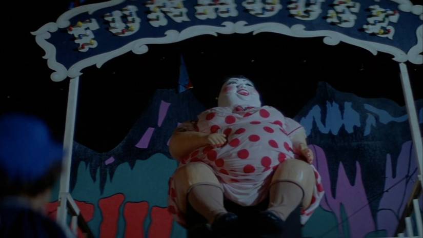 Uma grande mulher animatrônica abaixo do "Casa de diversões" sinal