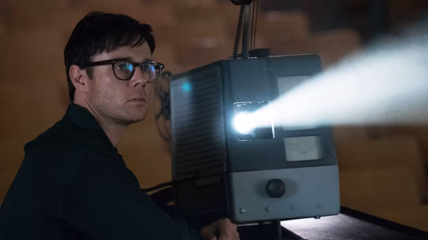 Frank Frink (Rupert Evans) observa um projetor assistindo a um filme