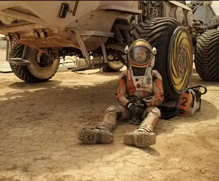Matt Damon, da Mark Watney, encosta-se a um rover de Marte em Marte