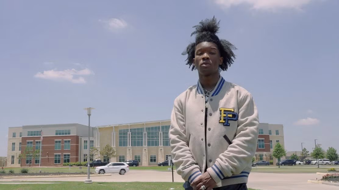 d4vd diante de um grande prédio escolar em uma foto