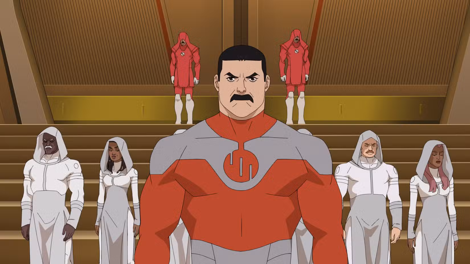 Thragg, um homem musculoso com cabelo preto e bigode, fica na frente de um grupo de Viltrumites encapuzados na 4ª temporada de Invincible