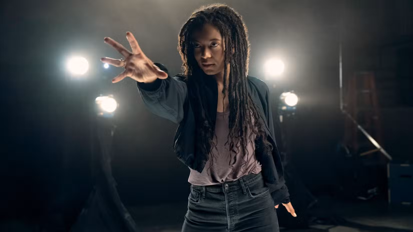 Marie Moreau (Jaz Sinclair) estende a mão para usar seus poderes enquanto holofotes brilham atrás dela na Geração V