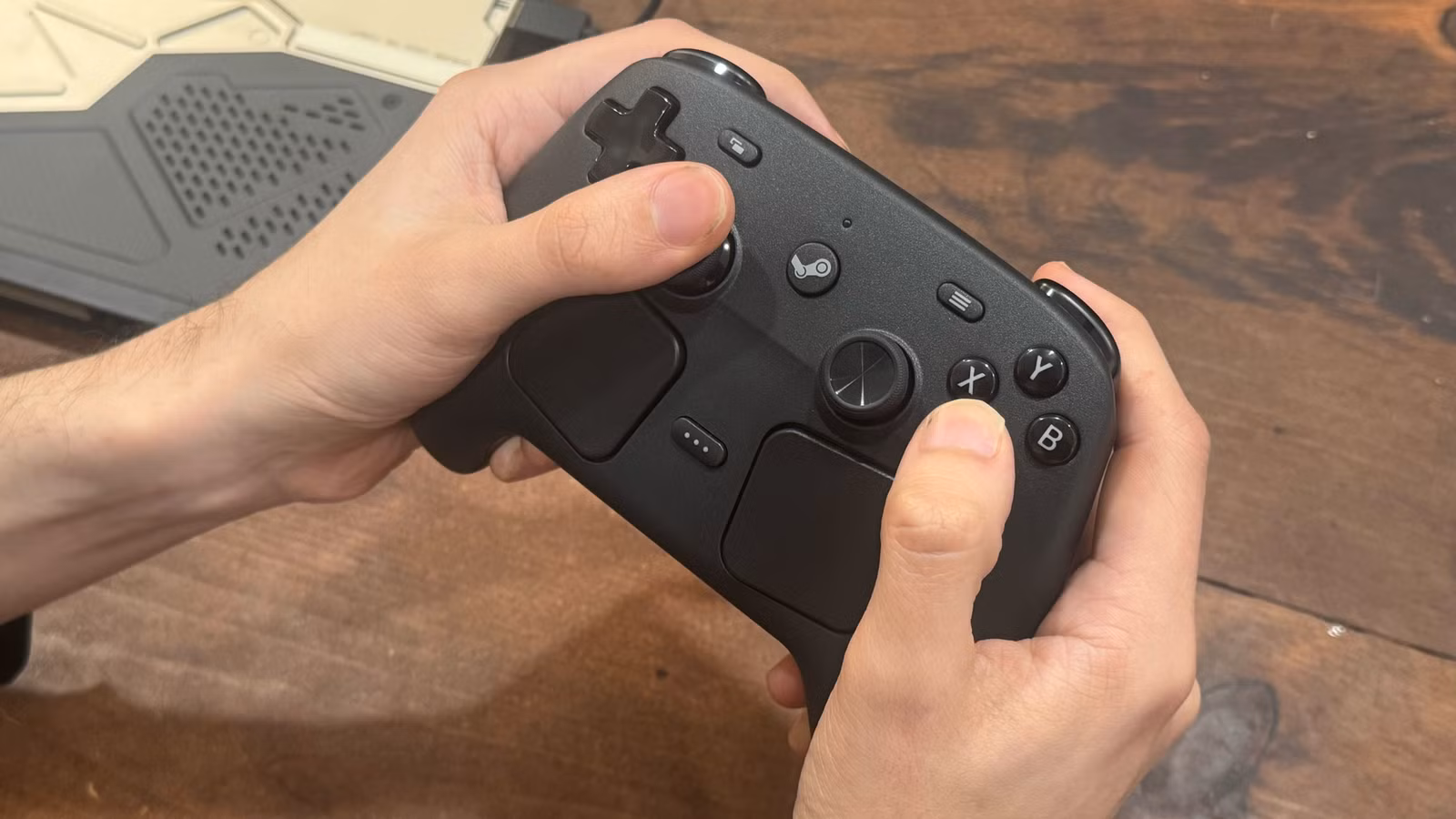 As mãos seguram um controlador Steam.