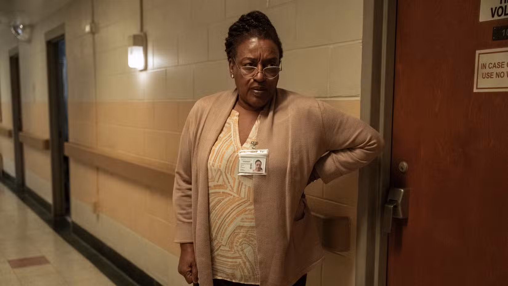 Senhorita Chris (CCH Pounder), uma enfermeira vestindo um suéter e um crachá, está em um corredor com uma aparência severa em The Terror: Devil in Silver